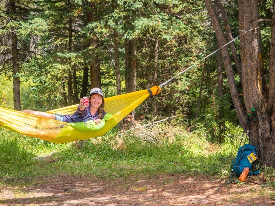 Women in Hammock, Hammock tied to trees drink in hand
